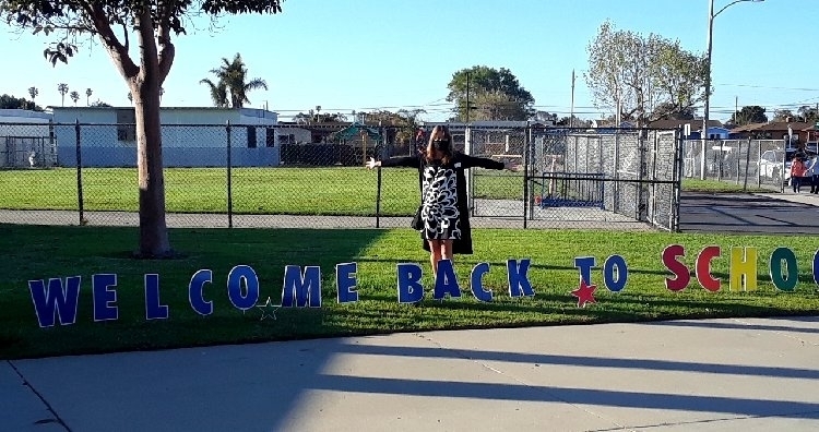 Mrs.Comstock with a welcome sign